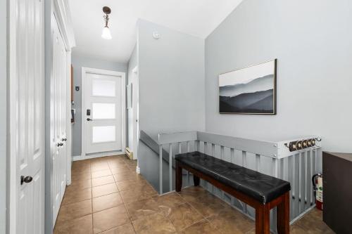 a hallway with a bench and a picture on the wall at L'Adirondacks in Stoneham