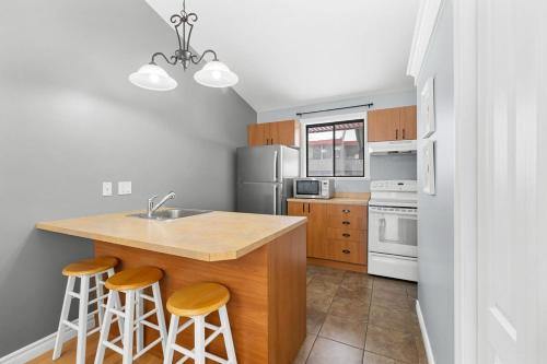 a kitchen with a sink and a counter with stools at L'Adirondacks in Stoneham