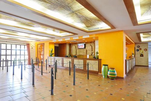 a lobby with a cafeteria with yellow walls at PortAventura Hotel El Paso - Includes unlimited access to PortAventura Park & 1 access to Ferrari Land in Salou