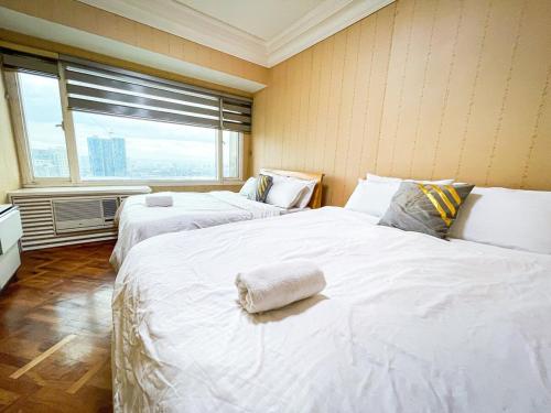 マニラにあるStunning & Luxury 4BR in Manila Bay White Beachの窓のある部屋に白いベッドが2つある