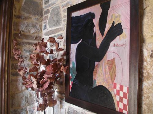 a picture of a woman in a painting on a wall at Iliopetra Suites in Agios Lavredios