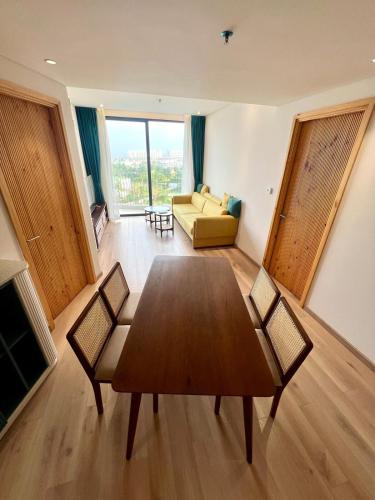 a living room with a table and chairs and a couch at Aqua Blue Ocean View Condo - Free Swimming Pool in Hà My Tây (2)