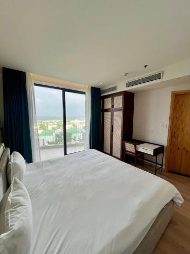 a bedroom with a large white bed with a large window at Aqua Blue Ocean View Condo - Free Swimming Pool in Hà My Tây (2)