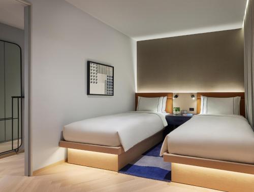 two beds in a hotel room with two beds at Lanson Place Parliament Gardens in Melbourne