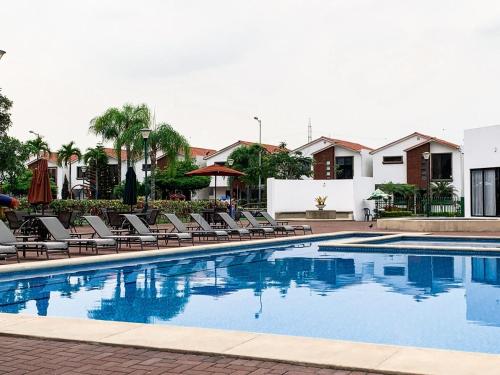a swimming pool with chaise lounge chairs in a resort at 3 dormitorios piscina privada BBQ parking free in SamborondÃ³n