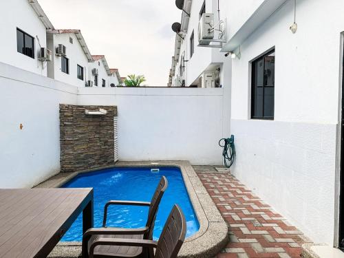 a small swimming pool with two chairs and a table at 3 dormitorios piscina privada BBQ parking free in SamborondÃ³n