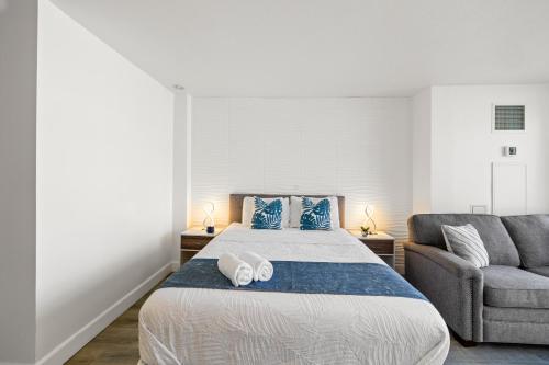 a bedroom with a large bed and a couch at Waikiki Ilikai Marina in Honolulu