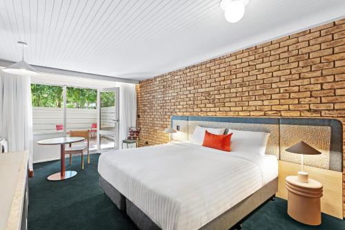 a bedroom with a bed and a brick wall at Motel Flinders in Flinders