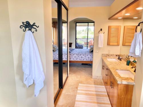 Un baño con dos lavabos y un espejo. en 622 Bay Club, en Waikoloa