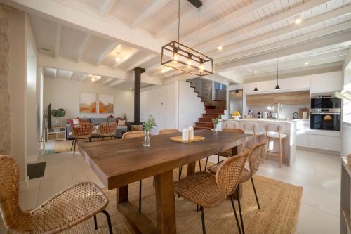 a dining room and kitchen with a wooden table and chairs at Siavo Junto a la Ría in Outes