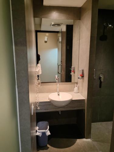 a bathroom with a sink and a mirror at Sweet Garden Guest House in Malang