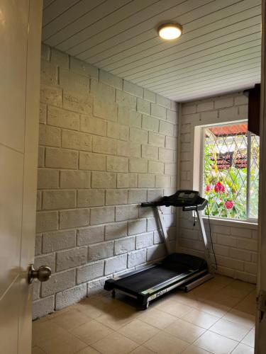 a room with a brick wall with a treadmill next to a window at CASA ENTERA HERMOSA con Desayunos incluidos in Puyo