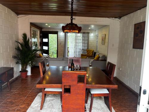 a dining room with a wooden table and chairs at CASA ENTERA HERMOSA con Desayunos incluidos in Puyo