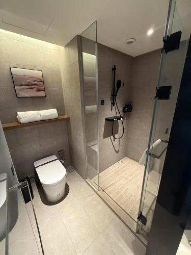 a bathroom with a toilet and a glass shower at Atour Hotel Wuhan Hidden Dragon Island Hubei University of Economics in Wuhan