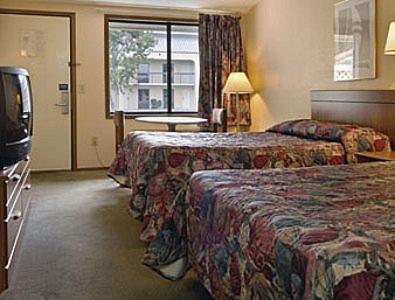 um quarto de hotel com duas camas e uma televisão em Knights Inn Greenville em Greenville