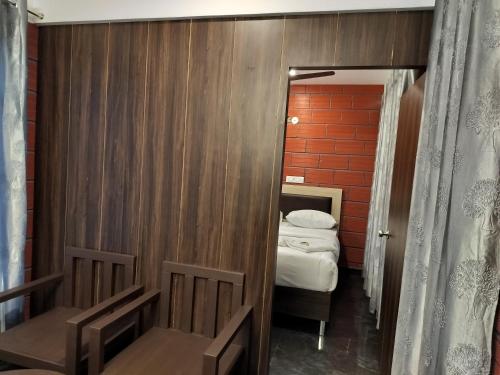 a small room with a bed and a mirror at RR inn in Yelagiri