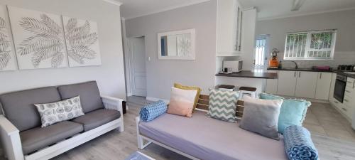 a living room with a couch and a kitchen at Pearly Bay in Pearly Beach