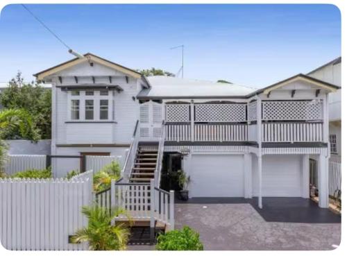 a white house with a white fence at Kent Street Retreat in Brisbane