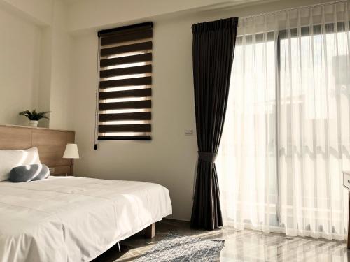 a bedroom with a bed and a large window at Komorebi homestay in Chiayi City