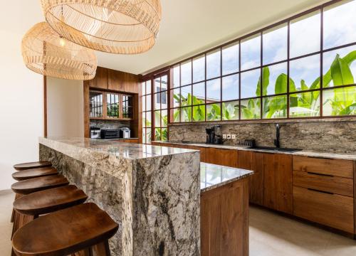 a kitchen with a large marble counter and stools at Plawa Laguna Bali in Canggu