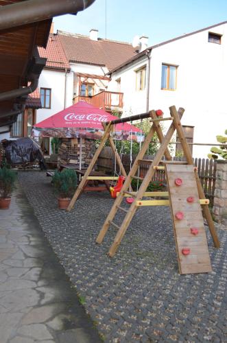 a wooden playground with a slide in a yard at Hotel u Kapra in Lázně Bělohrad