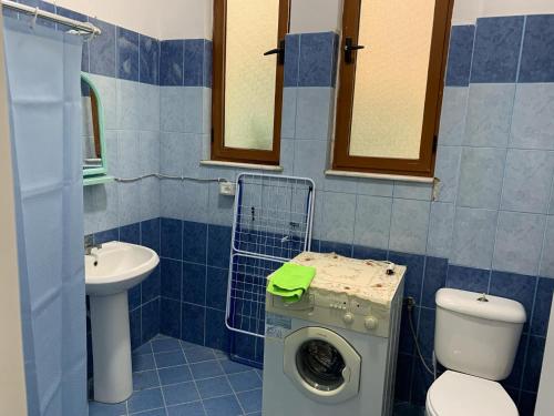 łazienka z toaletą, umywalką i pralką w obiekcie Beachside Studio w Durrës