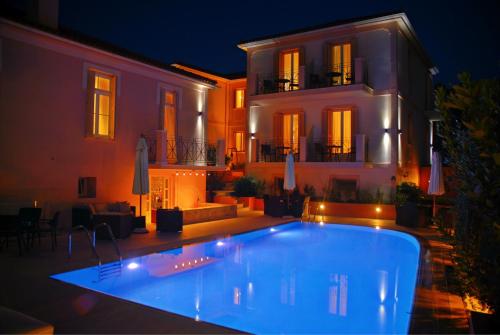 a swimming pool in front of a house at night at Korina Gallery Hotel in Vathi, Ithaka