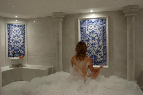 a woman sitting in a bubble bath in a tub of water at Hawaii Hotel in Marmaris