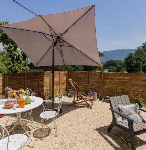 a patio with a table and an umbrella at Gite l 'Eternelle in Traize