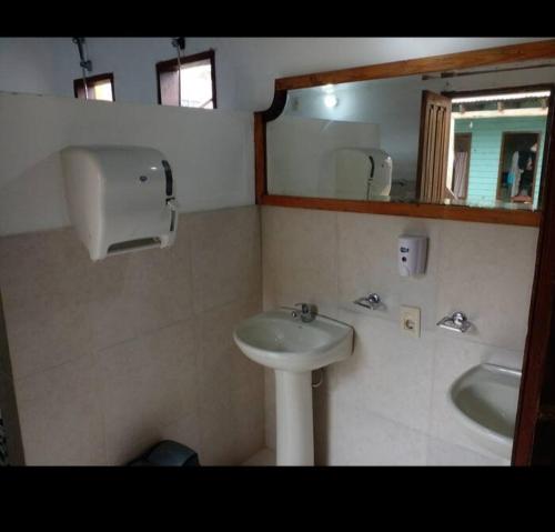 un baño con lavabo y espejo en Hostel Finisterre, en La Pedrera