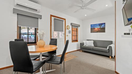 a living room with a table and a couch at Tasman Holiday Parks - Merool on the Murray in Echuca