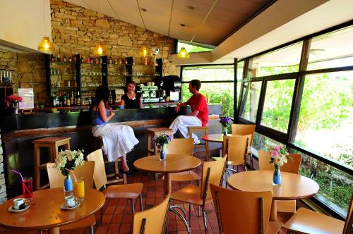 un groupe de personnes assises au bar d'un restaurant dans l'établissement VTF Le Domaine du Peyrichoux, à Singleyrac