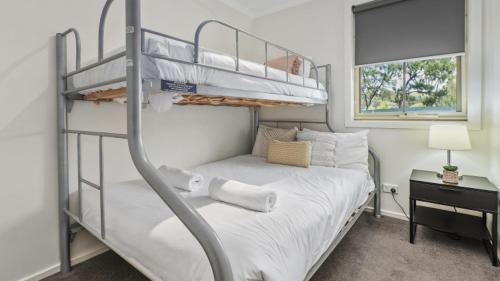 a bedroom with two bunk beds and a window at Tasman Holiday Parks - Merool on the Murray in Echuca