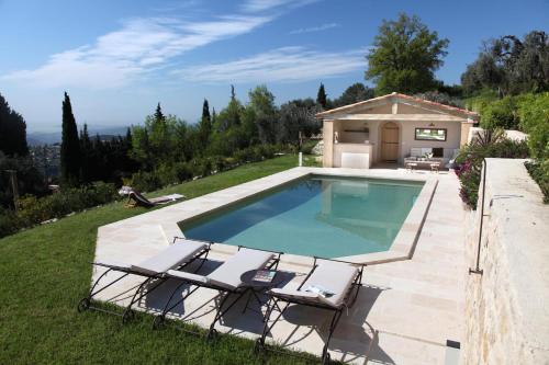 une piscine avec deux chaises et une maison dans l'établissement Olives et Libellules, à Vence