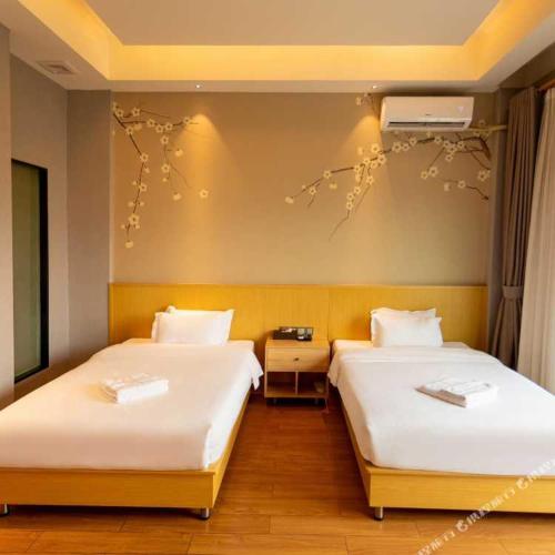 a hotel room with two beds at Hubei Hotel in Vientiane