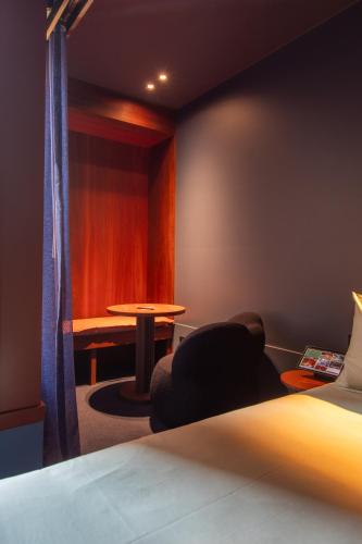 a room with a bed and a table and a chair at Hyde Melbourne Place in Melbourne