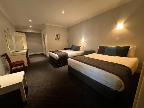 a hotel room with two beds and a table at St Francis Winery in Old Reynella