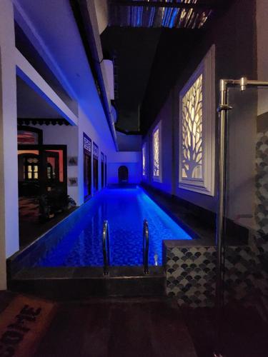 a swimming pool with blue lights in a house at Domore Lifestyle in Jetis