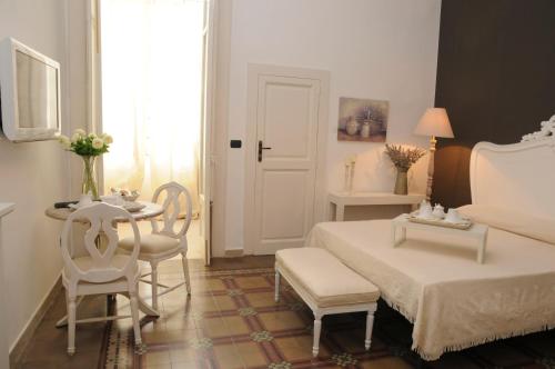 a bedroom with a bed and a table and chairs at Casa Blanca in Reggio Calabria