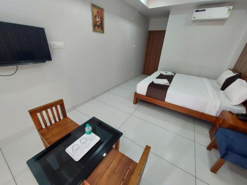 a bedroom with a bed and a table and a television at Wayanad Palace in Ambalavayal