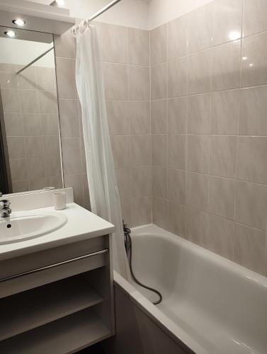 une salle de bain avec un lavabo, une baignoire et une douche dans l'établissement Résidence Le Hameau des Ecrins - maeva Home - Appartement 2 Pièces 4 Personnes - Confort MAE-6158, à Puy-Saint-Vincent