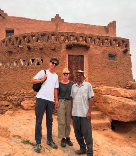 a group of three people standing in front of a building at Palais d'or in Taghit