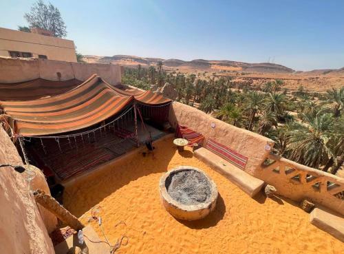 a view of a building in the desert with palm trees at Palais d'or in Taghit