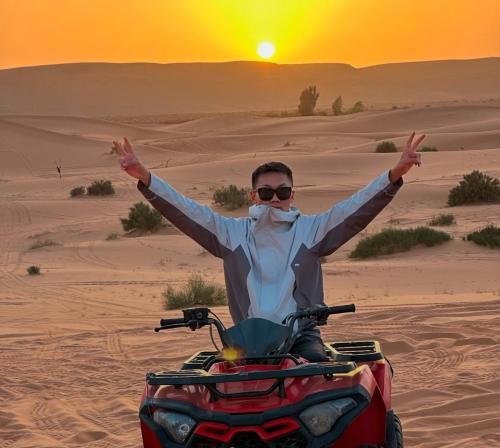 a man riding a quad bike in the desert at Palais d'or in Taghit