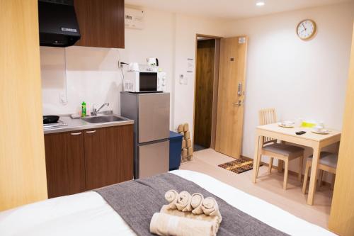 a room with a bed and a kitchen with a table at valuehjq VALUE NAMBA SOUTH III in Osaka