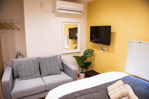 a living room with a couch and a tv at valuehjq VALUE NAMBA SOUTH III in Osaka