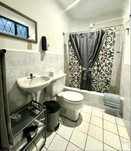 a bathroom with a toilet and a sink and a shower at San Roque Dpto in Cuenca