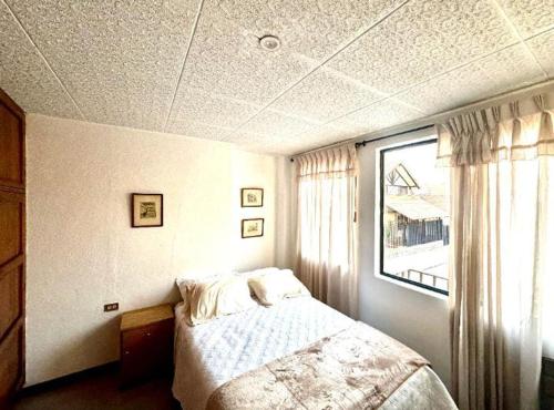 a bedroom with a bed and a window at San Roque Dpto in Cuenca
