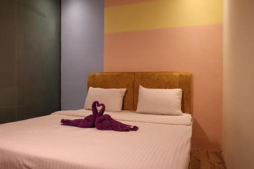 a stuffed animal sitting on top of a bed at Oscar Inn in Petaling Jaya