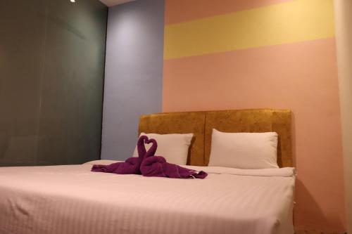 a stuffed animal is sitting on a bed at Oscar Inn in Petaling Jaya